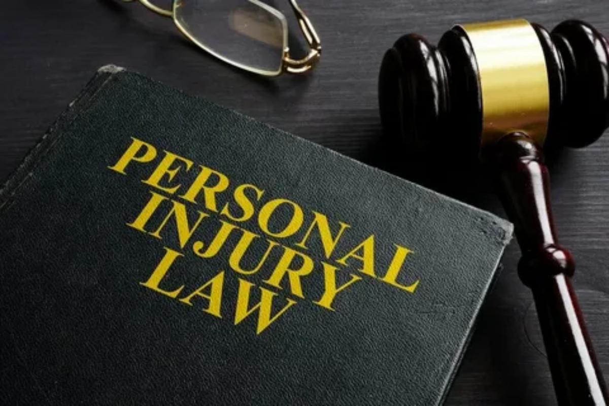 Personal injury lawyer concept with law book, gavel, and glasses representing justice and legal support for accident and injury victims.